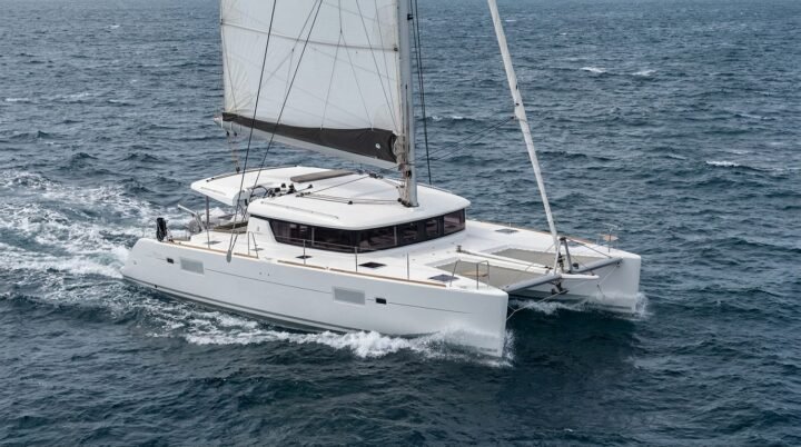 Catamarán de crucero navegando a vela en mar abierto, visto desde la aleta